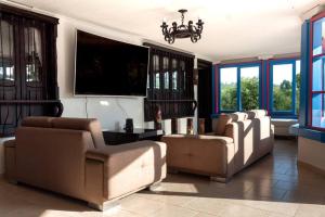 ein Wohnzimmer mit 2 Sofas und einem Flachbild-TV in der Unterkunft Espectacular casa de montaña in Pereira