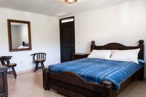 ein Schlafzimmer mit einem Bett, einem Spiegel und einem Stuhl in der Unterkunft Espectacular casa de montaña in Pereira