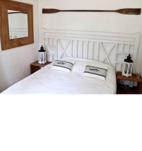 a bedroom with a white bed with two pillows on it at Magnifique villa golf du Touquet in Le Touquet-Paris-Plage