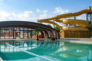 a water park with a slide and a swimming pool at Chalet Camping 5 étoiles Landes in Lit-et-Mixe