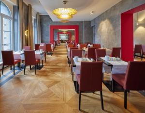 a dining room with tables and red chairs at Hotel Alte Post in Konstanz