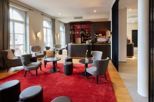 a lobby with chairs and tables on a red rug at Hotel Alte Post in Konstanz