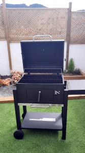 a grill sitting on the grass in a backyard at Kataenea. Apartamento en el prepirineo navarro. Naturaleza in Aoiz