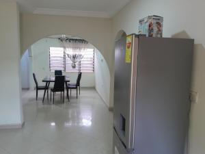 a dining room with a table and a refrigerator at Jiso Family Apartment in Tamale