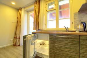 a kitchen with an empty refrigerator and a window at Pas Edgarą 2 in Nida +8 photos