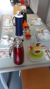 a table with plates and cups and a tea pot at L'Aurosée in Savièse