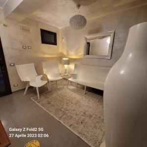 ein Wohnzimmer mit einem Tisch, Stühlen und einem Spiegel in der Unterkunft Raggi di Sole in Custonaci