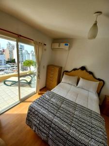 a bedroom with a bed and a large window at Piso exclusivo en Rosario! "Altos de Rosario" in Rosario