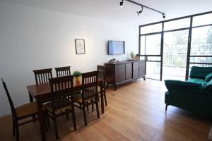 a living room with a table and chairs and a couch at Appartement luxueux à Jérusalem - Katamon in Giv‘at Mordekhay