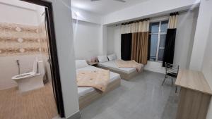 Hotel Aashirwad في Chamoli: غرفة صغيرة بسريرين ونافذة