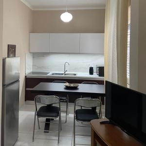 a kitchen with a table and chairs and a refrigerator at Andrea House in Berat
