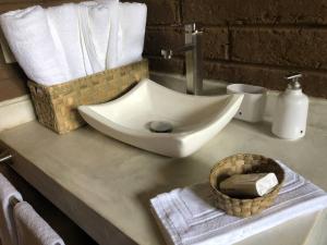 a bathroom counter with a sink and a basket of towels at Cabaña Los Franceses in Tapalpa