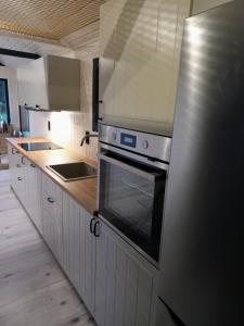 a kitchen with white cabinets and a stove top oven at Przystanek Mazury.Makosieje in Makosieje +57 photos