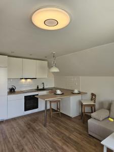 cocina y sala de estar con mesa y sofá en Apartament w sercu Oliwy en Gdansk