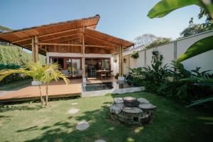 a house with a fire pit in the yard at Villa Fruta del Cielo in Uvita