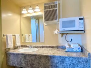 a bathroom with a sink and a microwave at Dockside Inn in Cold Lake