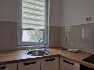 a kitchen with a sink and a window at N&M Apartment in Pirot