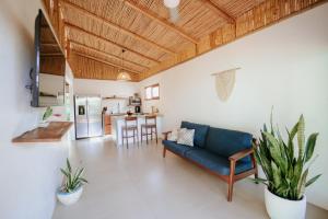 a living room with a blue couch and a kitchen at Villa Fruta del Cielo in Uvita