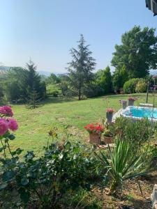 a garden with a swimming pool and flowers at B&B Casa Favari in Montalbo