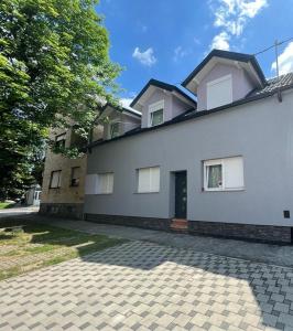a large white house with a driveway in front of it at Apartment Impression in Osijek