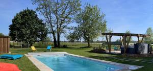 a swimming pool in a yard with a gazebo at Gite au gré de la Loire: massage, piscine et spa in Saint-Mathurin