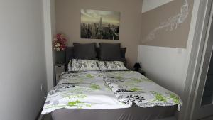 a bedroom with a bed with a white and green comforter at Apartment Impression in Osijek