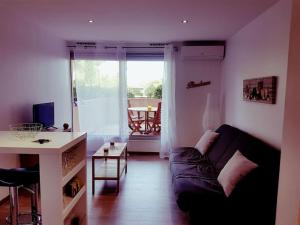 ein Wohnzimmer mit einem Sofa und einem Tisch in der Unterkunft Logement cosy, calme, vue mer, sud France in La Seyne-sur-Mer