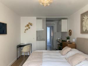 1 dormitorio con cama, escritorio y cocina en Les Suites de Vanves - Parc des expositions Porte de Versailles, en Vanves