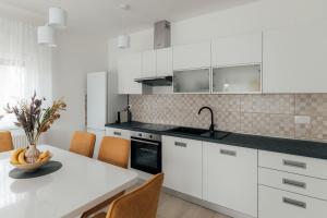 a kitchen with white cabinets and a table and chairs at Eko Natura, Tušilović, Hrvatska in Durići