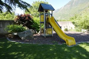 a playground with a yellow slide in a yard at Appartement Quellenhof in Naturno
