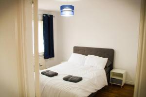 a bed with two pillows on it in a room at Luxury House in Colnbrook near Windsor & Heathrow in Colnbrook