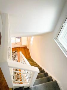 a staircase in a house with a white stair case at Luxury House in Colnbrook near Windsor & Heathrow in Colnbrook