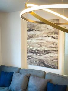 una sala de estar con un sofá azul y una pintura en Luxury House in Colnbrook near Windsor & Heathrow, en Colnbrook
