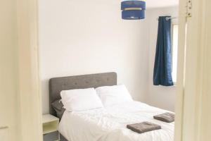 a bed with white sheets and pillows in a bedroom at Luxury House in Colnbrook near Windsor & Heathrow in Colnbrook