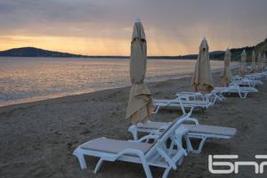 a group of lounge chairs and umbrellas on a beach at Sea angel in Burgas City