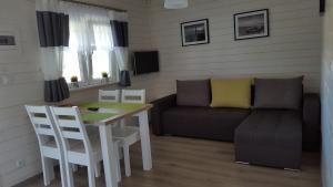 een woonkamer met een bank en een tafel bij Domki Ewa in Sarbinowo