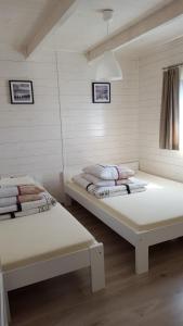 2 łóżka w pokoju z białymi ścianami w obiekcie Domki Ewa w Sarbinowie