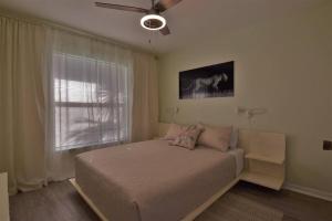 1 dormitorio con 1 cama y ventilador de techo en Florinda 3bdr/2bth 2car garage with New Pool, en Sarasota