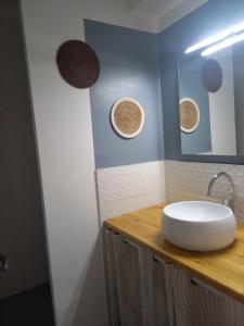 La salle de bains est pourvue d'un lavabo et d'un miroir. dans l'établissement Appartement climatisé avec terrasse parking piscine et terrains de tennis, au Cap d'Agde