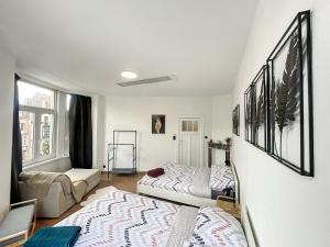 a bedroom with two beds and a couch at Hypercentre 4 in Brussels