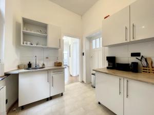 eine Küche mit weißen Schränken und einer Arbeitsplatte in der Unterkunft Cosy Apartment Brussels - City Center in Brüssel