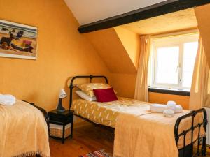 a bedroom with two beds and a window at Higgledy Piggledy Cottage in Swanage