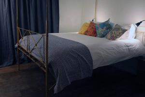 Una cama con marco de metal y almohadas. en Rusutu Ski Chalet - Six Bedrooms, BBQ, Lake Toya., en Rusutsu