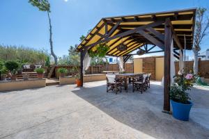 taras ze stołem i krzesłami pod pawilonem w obiekcie Selana House with outdoor pool w mieście Kos