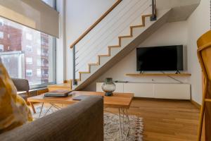 sala de estar con TV de pantalla plana y escaleras en Viví este Sensacional Duplex con Diseño Moderno - 604 - en Buenos Aires