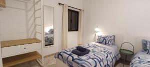 アルブフェイラにあるCasa "Os Amados"のベッドルーム(ベッド1台、鏡付)