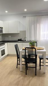 a kitchen with a white table and chairs and a table and a table at Apartamento Retama Laguna Centro in Las Lagunas