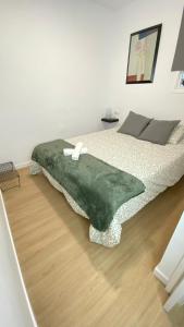 a bedroom with a green blanket on a bed at Apartamento Retama Laguna Centro in Las Lagunas