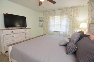 Schlafzimmer mit einem Bett und einem Flachbild-TV in der Unterkunft New England 3bd 2bt Home Heated Pool Close to Siesta in Sarasota