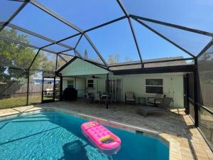 einem Pool mit einem Kunststofffloß im Wasser in der Unterkunft New England 3bd 2bt Home Heated Pool Close to Siesta in Sarasota